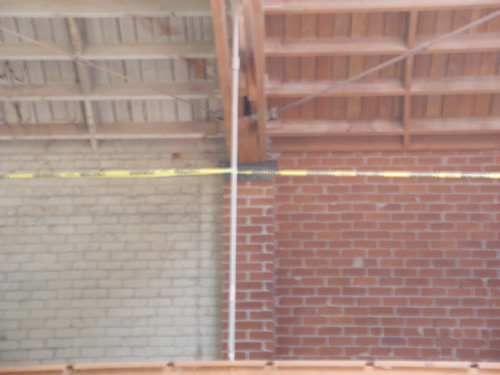 Muro de ladrillo a medio trabajo: a la izquierda pintado, a la derecha el ladrillo limpio